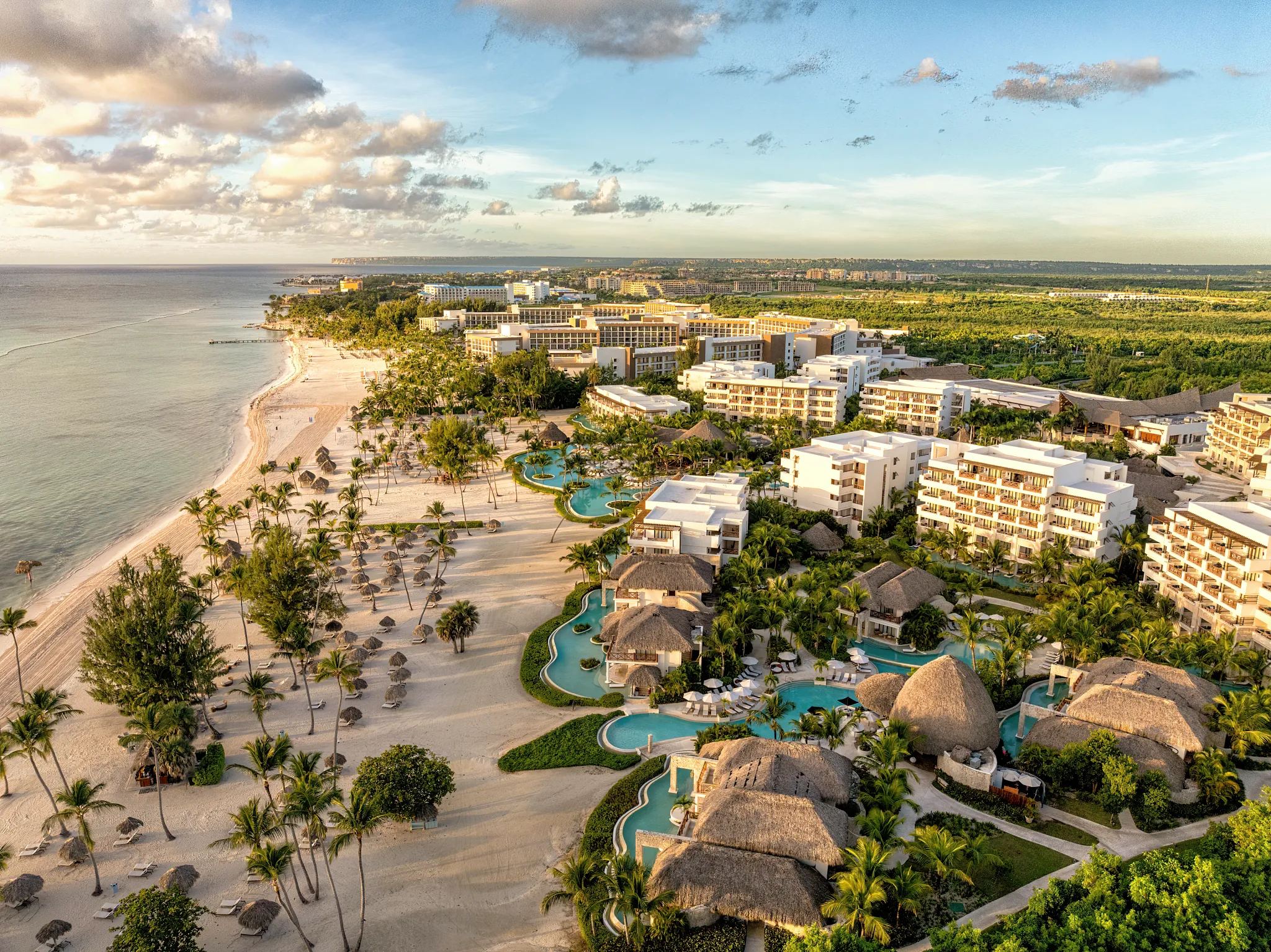 Elevated aerial view of Secrets Cap Cana Resort & Spa showcasing its beachfront location, tropical landscaping, and luxury accommodations.