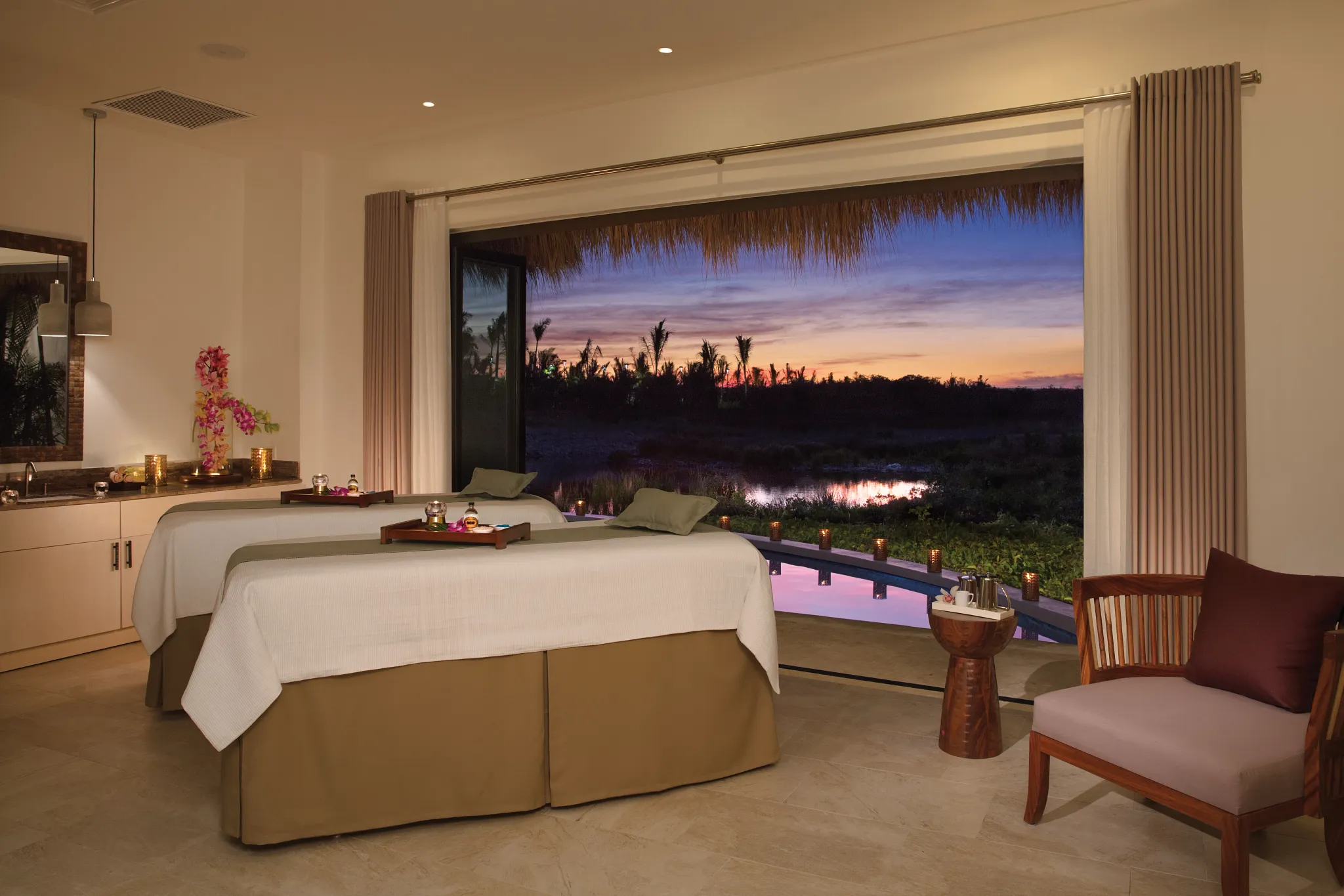 Luxury spa treatment suite with massage tables and scenic lagoon views at Secrets Cap Cana Resort & Spa.
