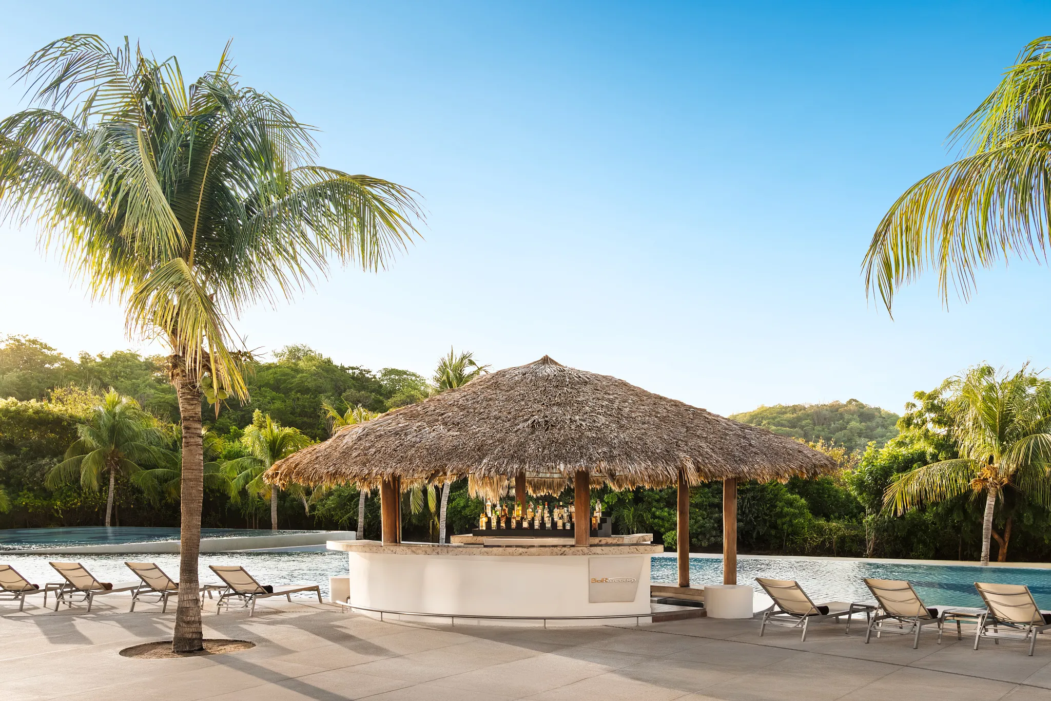 Barracuda pool and beach bar at Secrets Huatulco serving tropical cocktails with ocean views