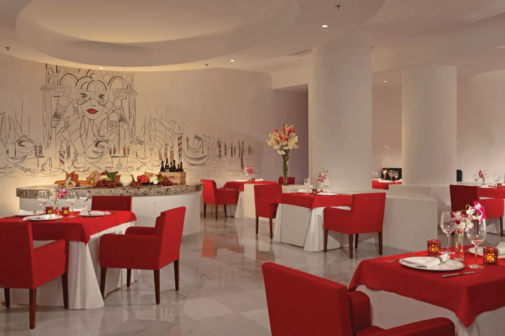 CinCin Italian restaurant at Secrets Huatulco Resort & Spa featuring modern trattoria-style décor, red-accented seating, and elegant Mediterranean dining ambiance.