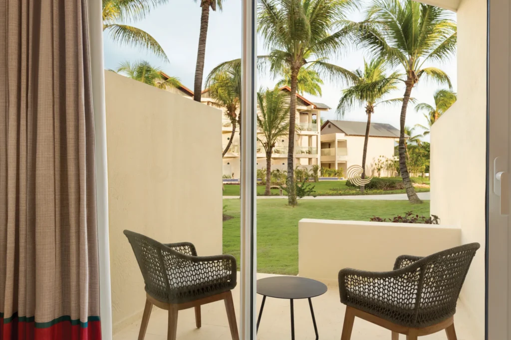 Private furnished terrace with garden views at the Deluxe Garden View Accessible room at Secrets La Romana Resort & Spa.