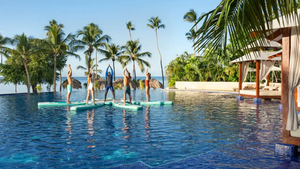 Guests participating in a floating fitness class at the infinity pool at Secrets La Romana Resort & Spa.