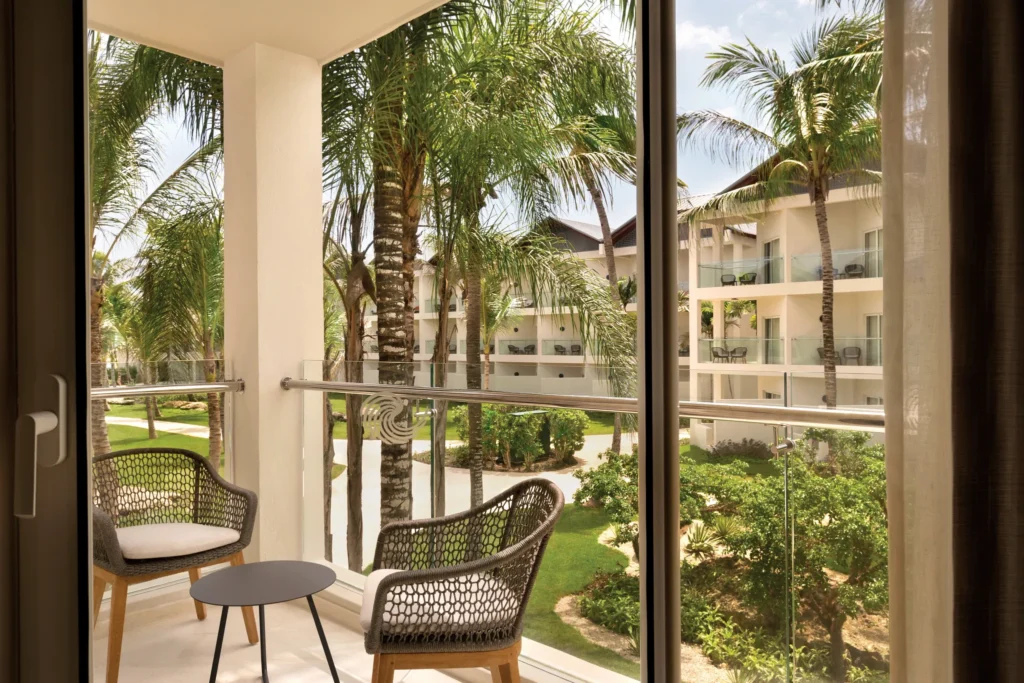 Private furnished balcony with tropical garden views at the Premium Garden View room at Secrets La Romana Resort & Spa.
