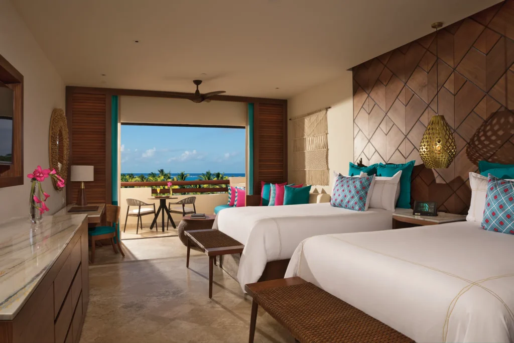Junior Suite Partial Ocean View with two double beds and furnished balcony at Secrets Maroma Beach Riviera Cancun.