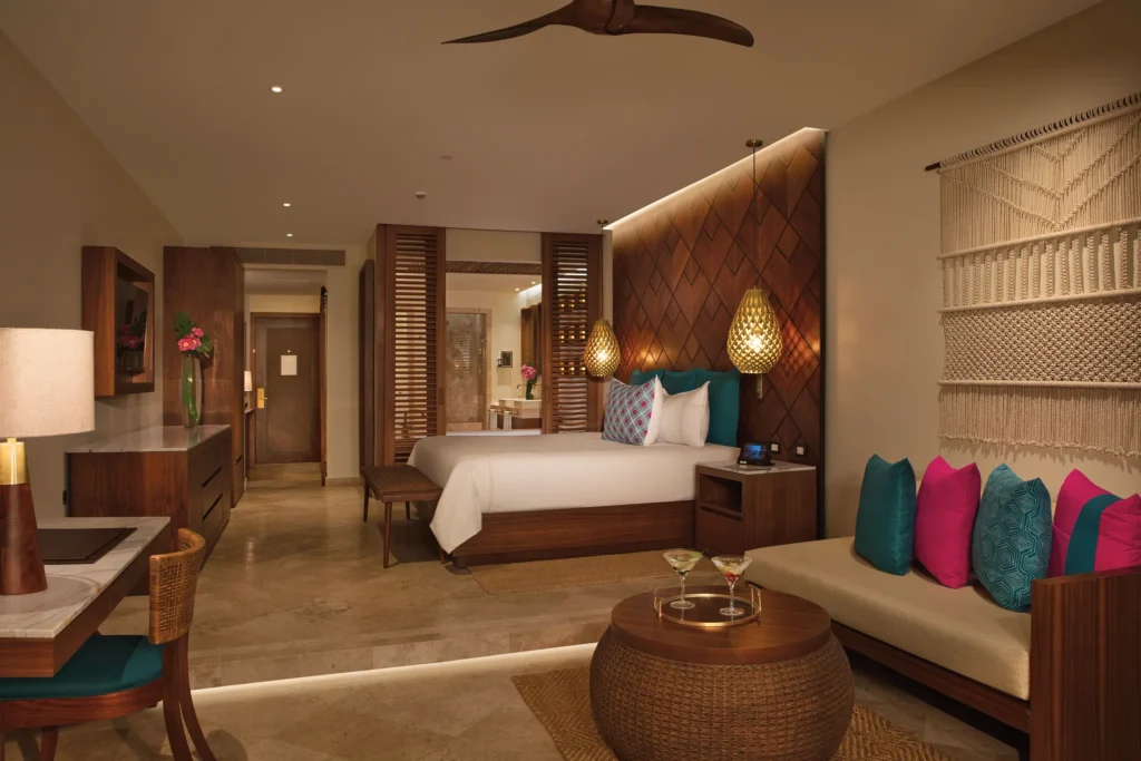 Junior Suite Swim Out with king-size bed, separate sitting area, and warm wood accents at Secrets Maroma Beach Riviera Cancun.