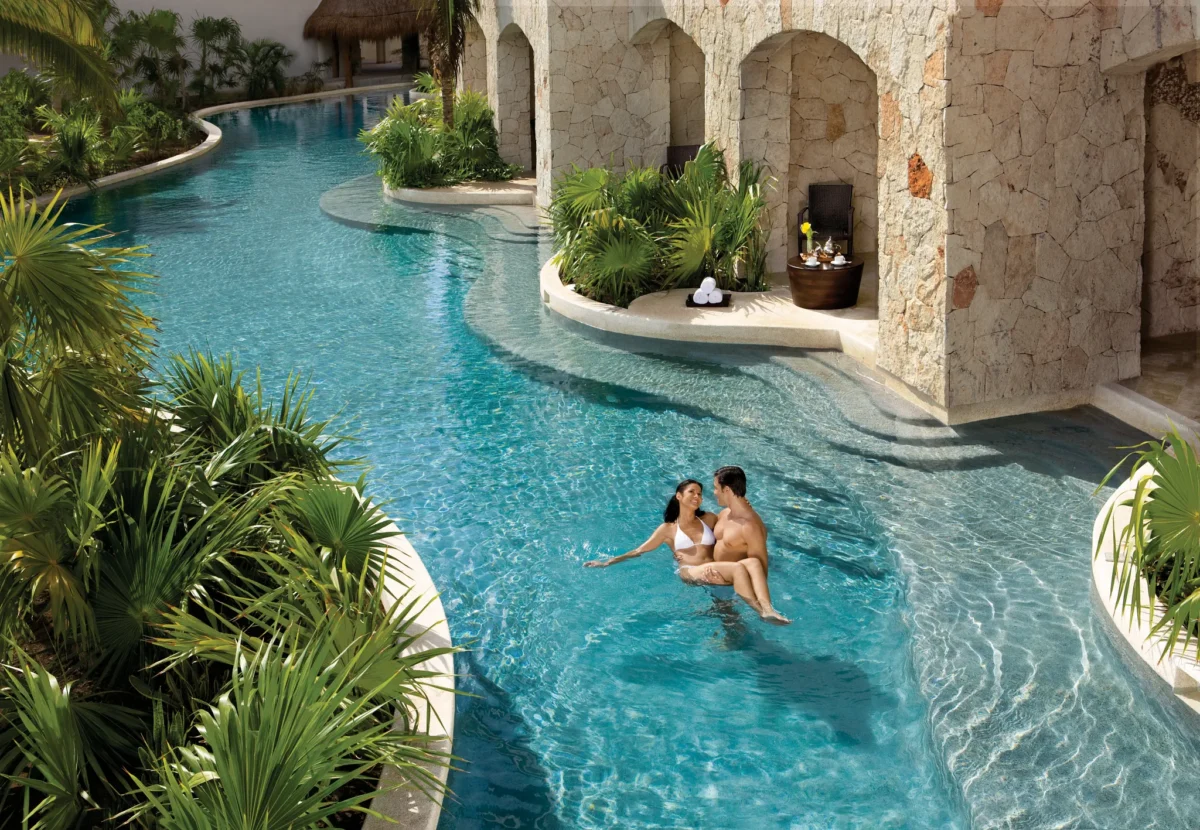 Couple enjoying swim-out pool access at Secrets Maroma Beach Riviera Cancun.