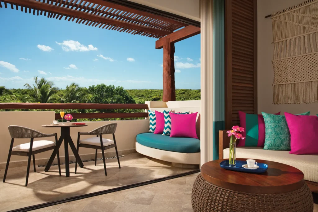 Private terrace with lounge seating and tropical garden views at Junior Suite Tropical View, Secrets Maroma Beach Riviera Cancun.