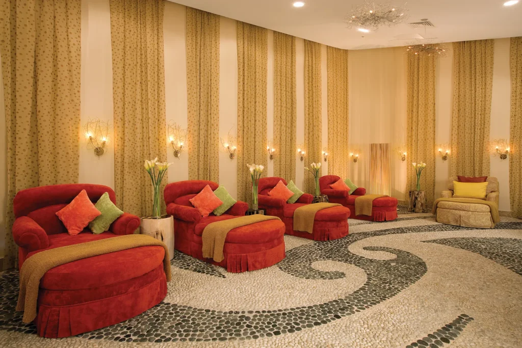 VIP spa lounge with plush red chairs and soothing ambiance at Secrets Maroma Beach Riviera Cancun.
