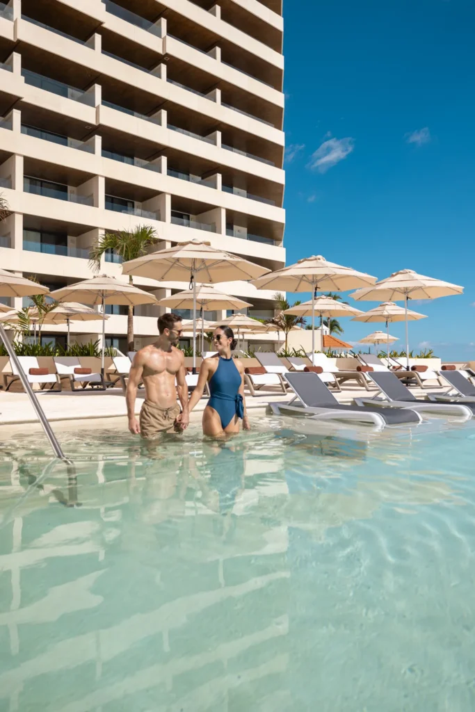 Couple walking through the resort pool at Secrets Mirabel Cancun Resort & Spa in Cancun.