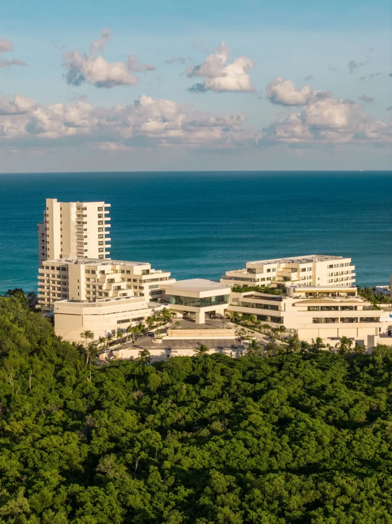 Aerial view of Secrets Mirabel Cancun Resort & Spa surrounded by lush greenery and ocean views in Cancun.