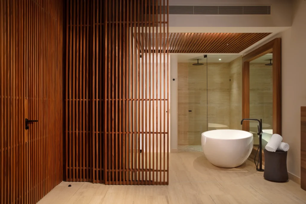 Junior Suite bathroom with freestanding soaking tub and rain shower at Secrets Playa Blanca Costa Mujeres.