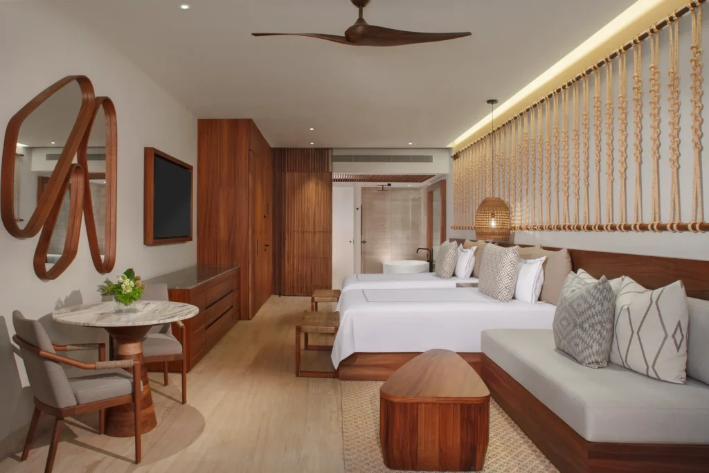 Junior Suite with two double beds and tropical-inspired décor at Secrets Playa Blanca Costa Mujeres.