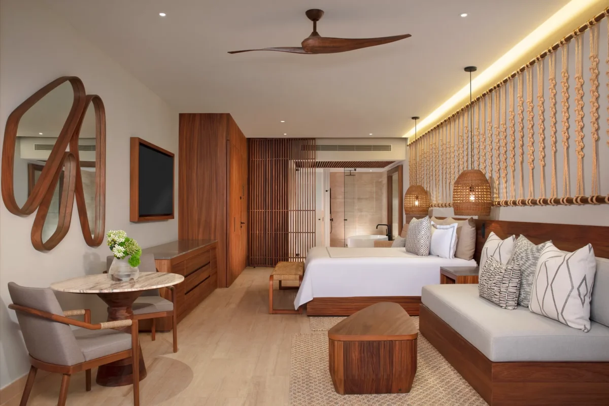 Junior Suite Swim Out with king bed, sofa seating, and terrace access at Secrets Playa Blanca Costa Mujeres.