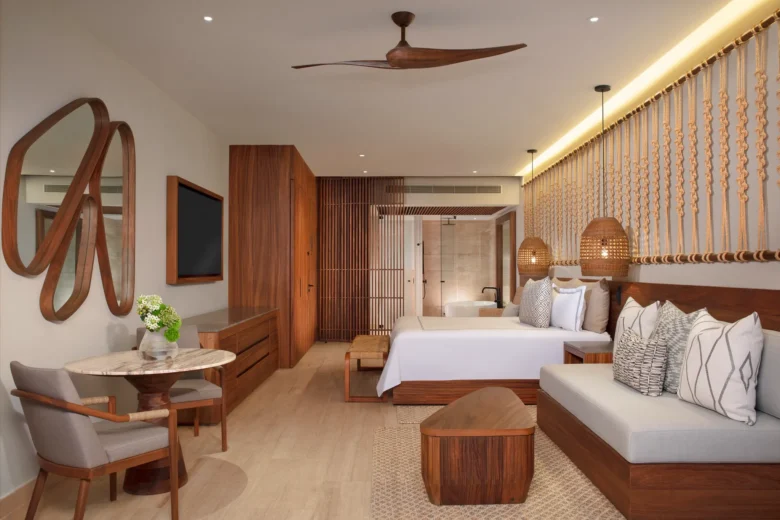Junior Suite Swim Out with king bed, sofa seating, and terrace access at Secrets Playa Blanca Costa Mujeres.