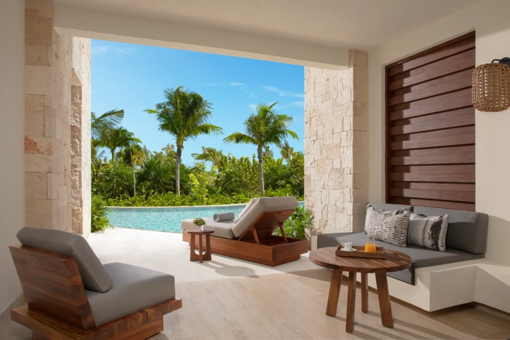 Private swim-out terrace with lounge chairs and pool overlooking ocean at Secrets Playa Blanca Costa Mujeres.