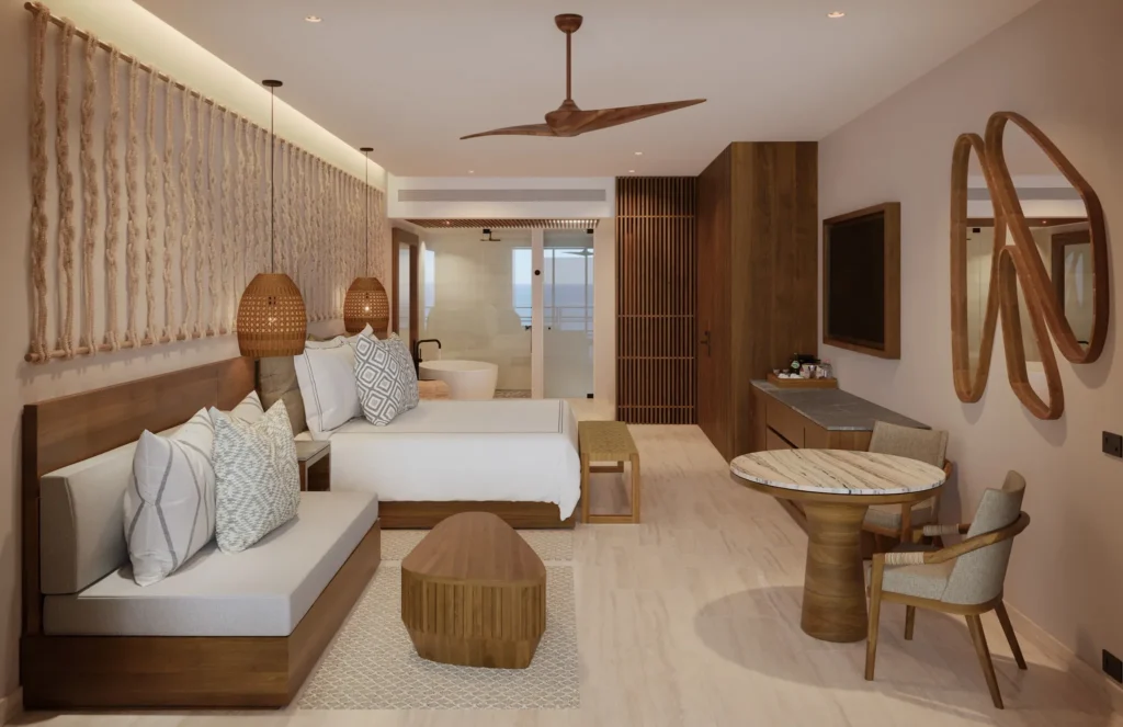 Preferred Club Junior Suite Tropical View with king bed and modern seating area at Secrets Playa Blanca Costa Mujeres.