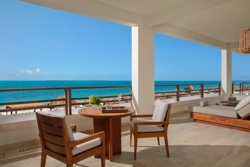 Corner oceanfront terrace with seating and panoramic sea views at Secrets Playa Blanca Costa Mujeres master suite.