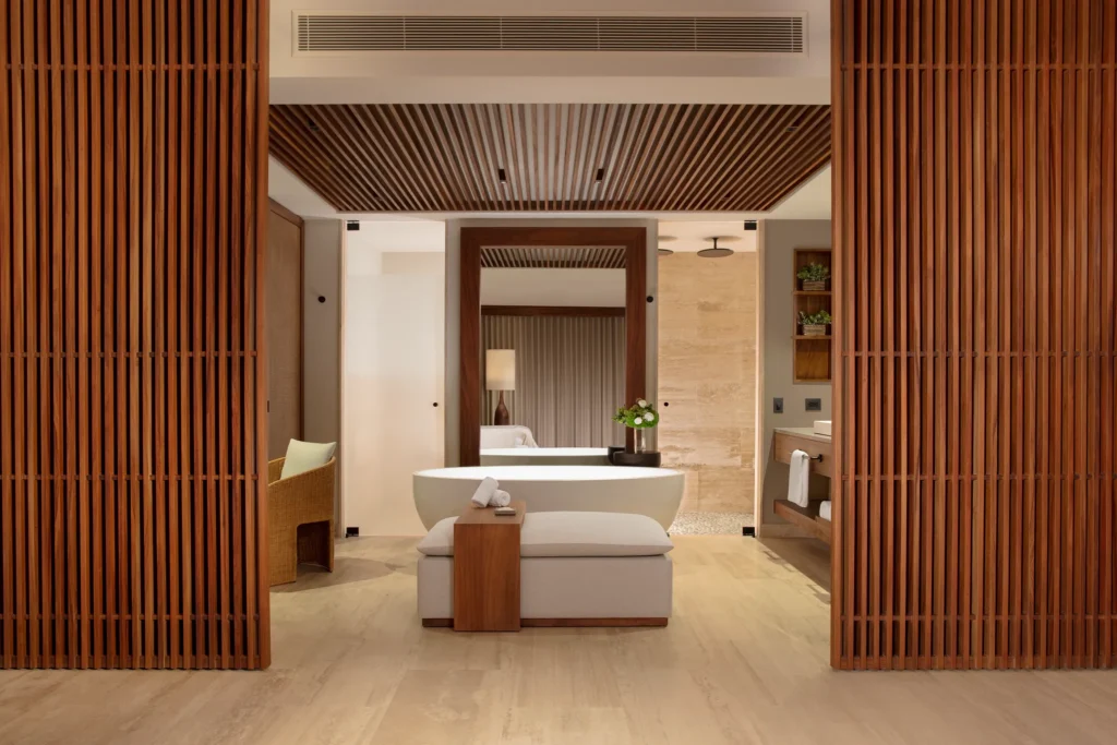 Luxury bathroom with freestanding soaking tub and wood accents at Secrets Playa Blanca Costa Mujeres suite.