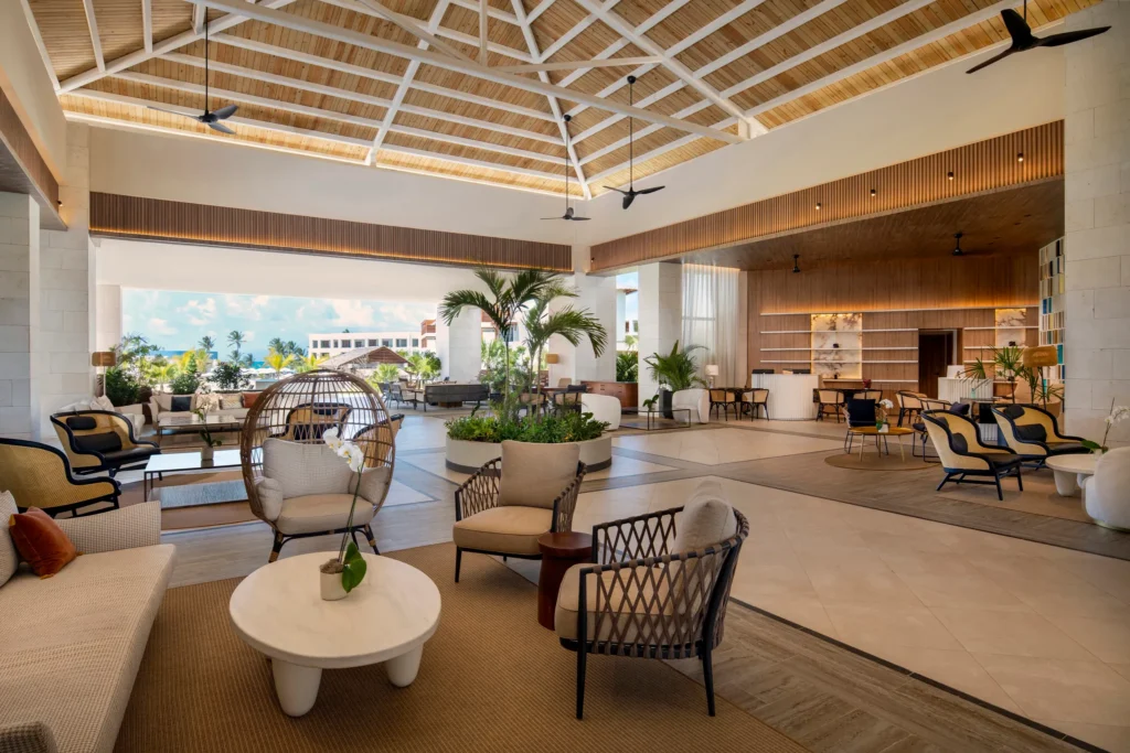 Open-air luxury lobby with modern seating and tropical design at Secrets Playa Esmeralda Resort & Spa.