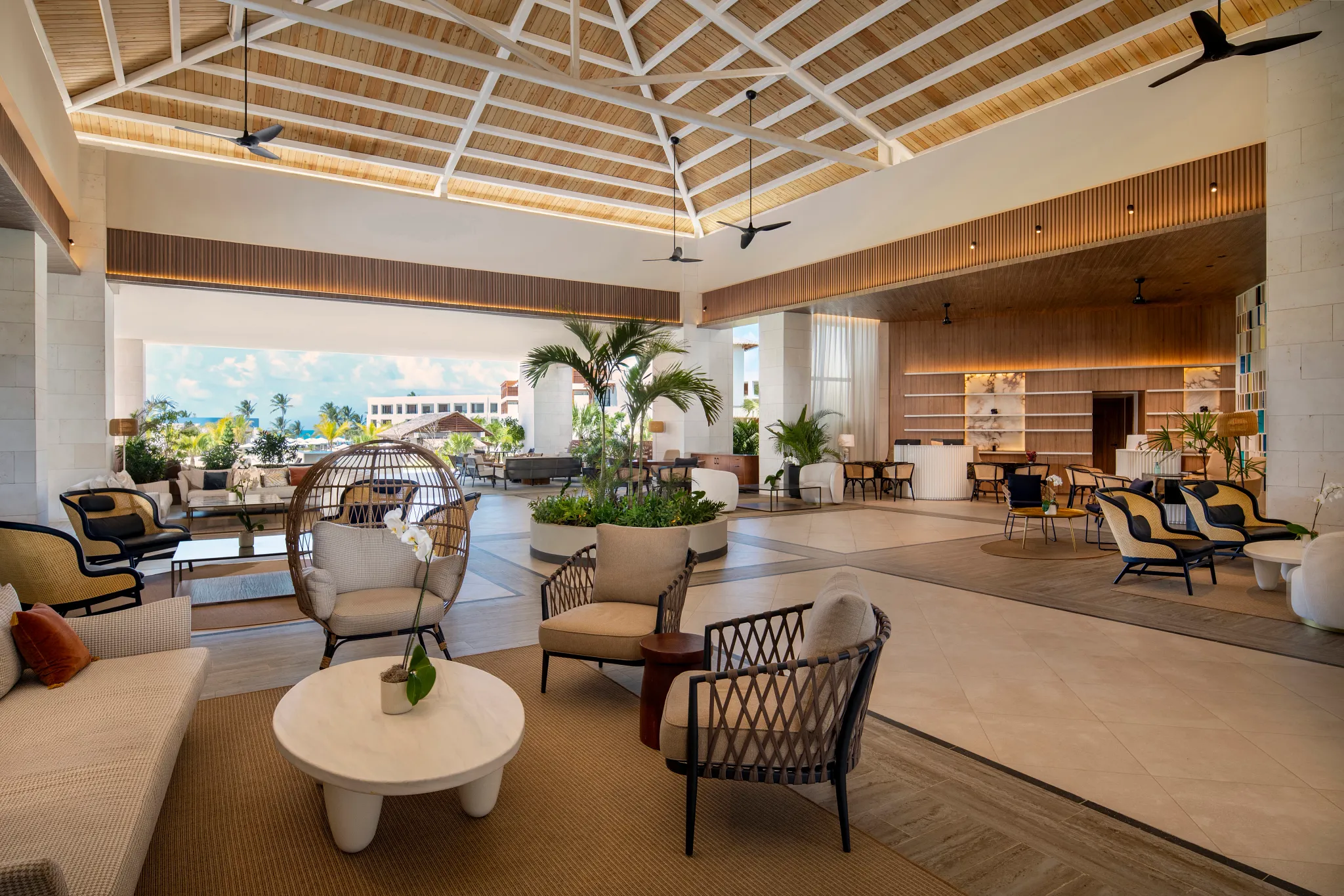 Open-air luxury lobby with modern seating and tropical design at Secrets Playa Esmeralda Resort & Spa.