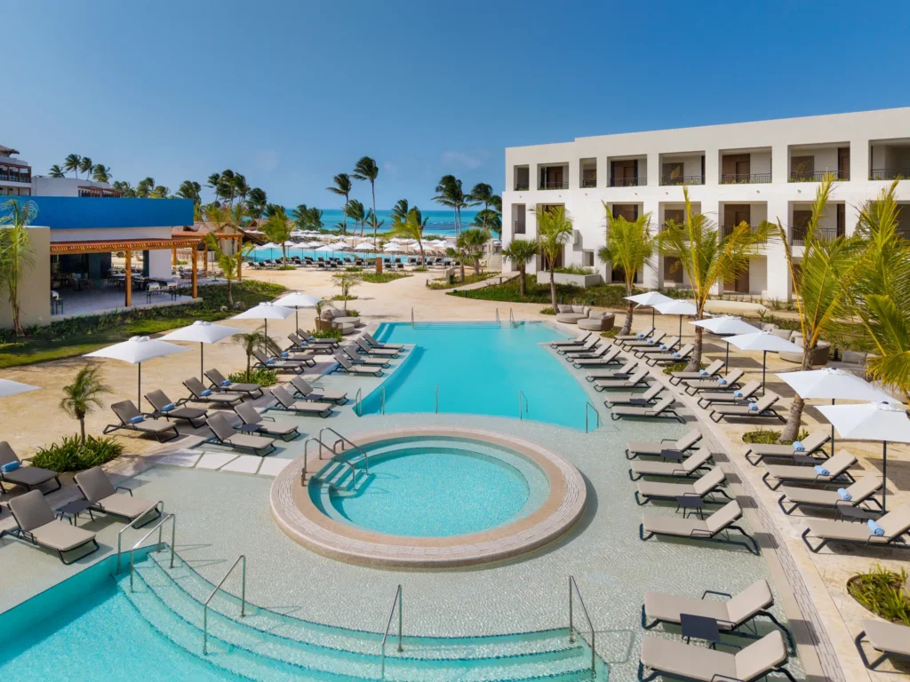 Large resort pool with loungers and umbrellas at Secrets Playa Esmeralda Resort & Spa.