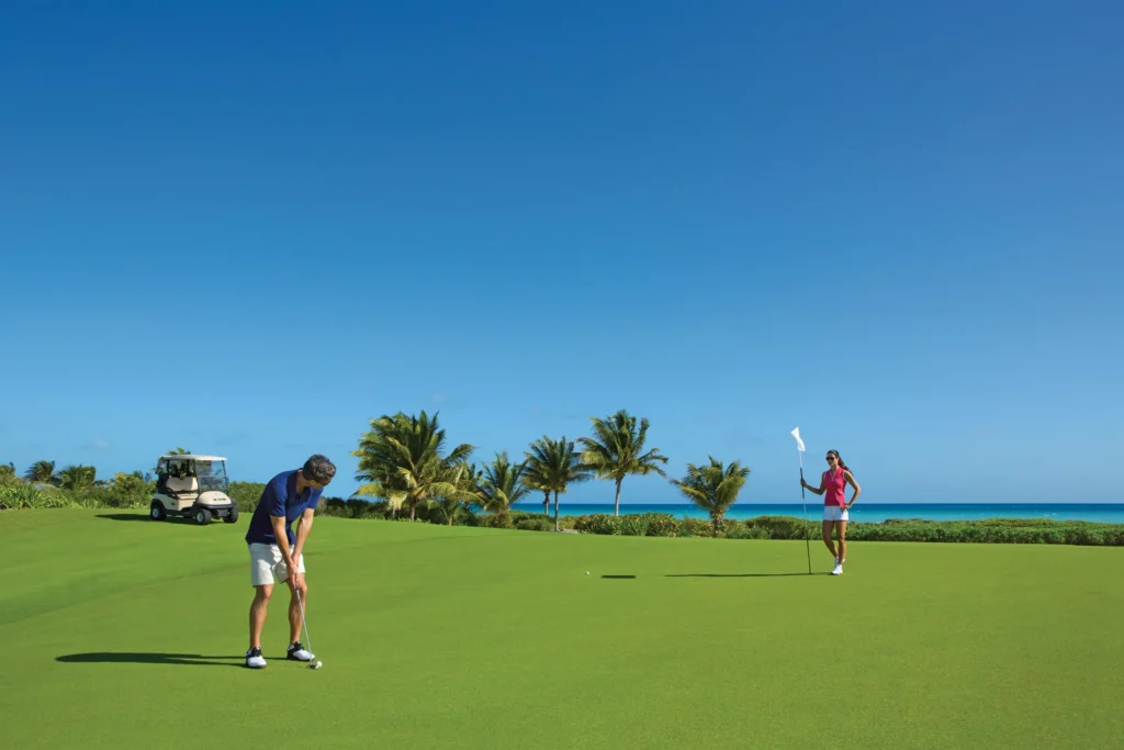 Guests playing golf at the oceanfront Playa Mujeres Golf Club near Secrets Playa Mujeres Golf & Spa Resort.