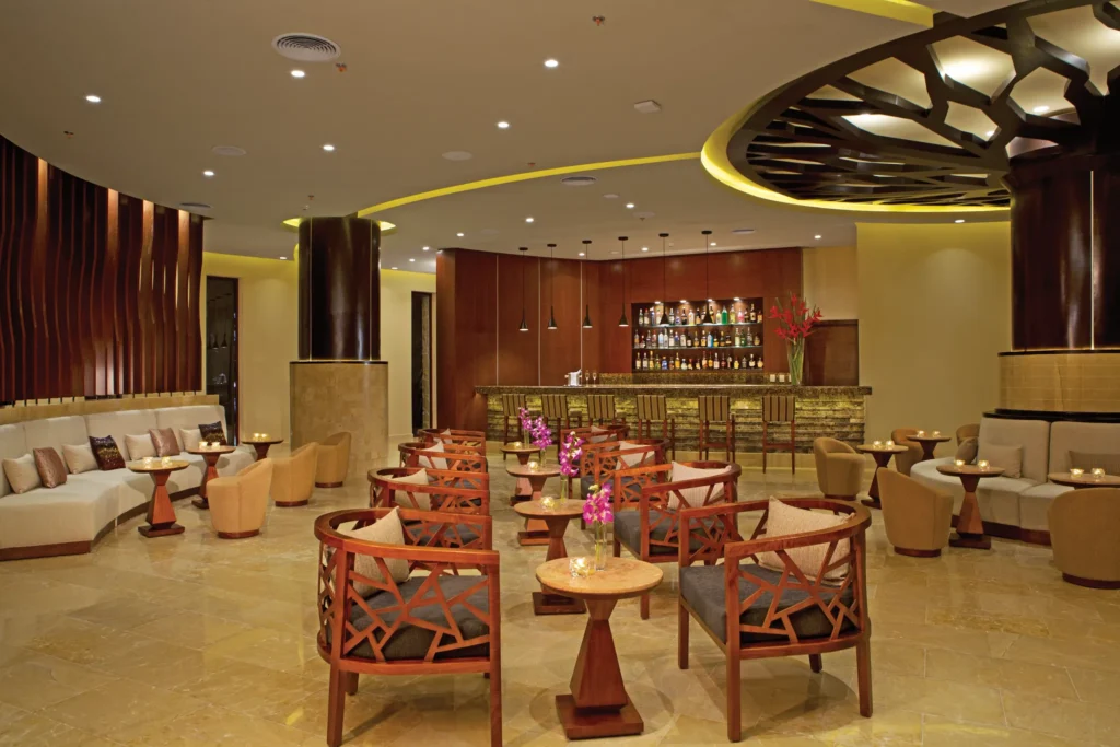 Rendezvous Lobby Bar at Secrets Playa Mujeres Golf & Spa Resort featuring elegant lounge seating, stylish bar, and contemporary décor.