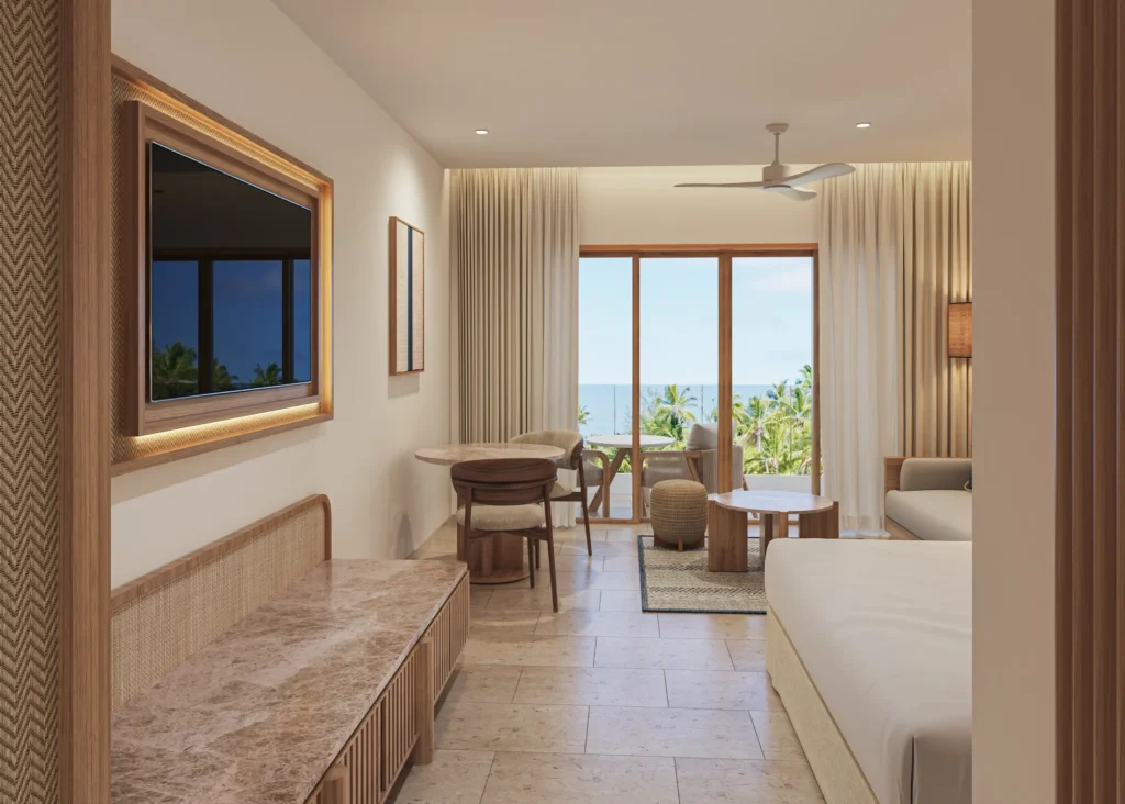 Junior Suite Partial Ocean View with seating area and private furnished balcony at Secrets Playa Mujeres Golf & Spa Resort.