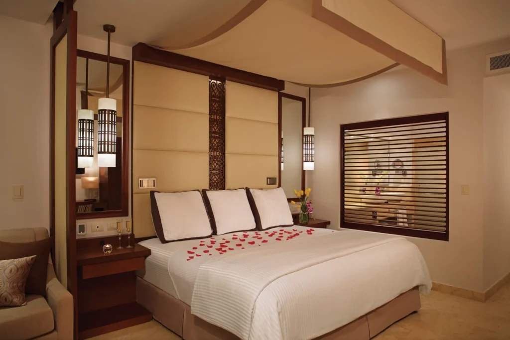 Junior Suite Partial Ocean View king bed with romantic turndown service at Secrets Playa Mujeres Golf & Spa Resort.