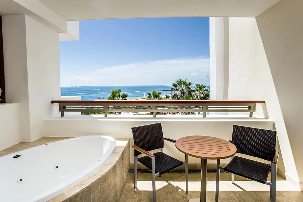 Preferred Club Junior Suite Ocean View balcony with whirlpool tub and Caribbean Sea views at Secrets Playa Mujeres Golf & Spa Resort.