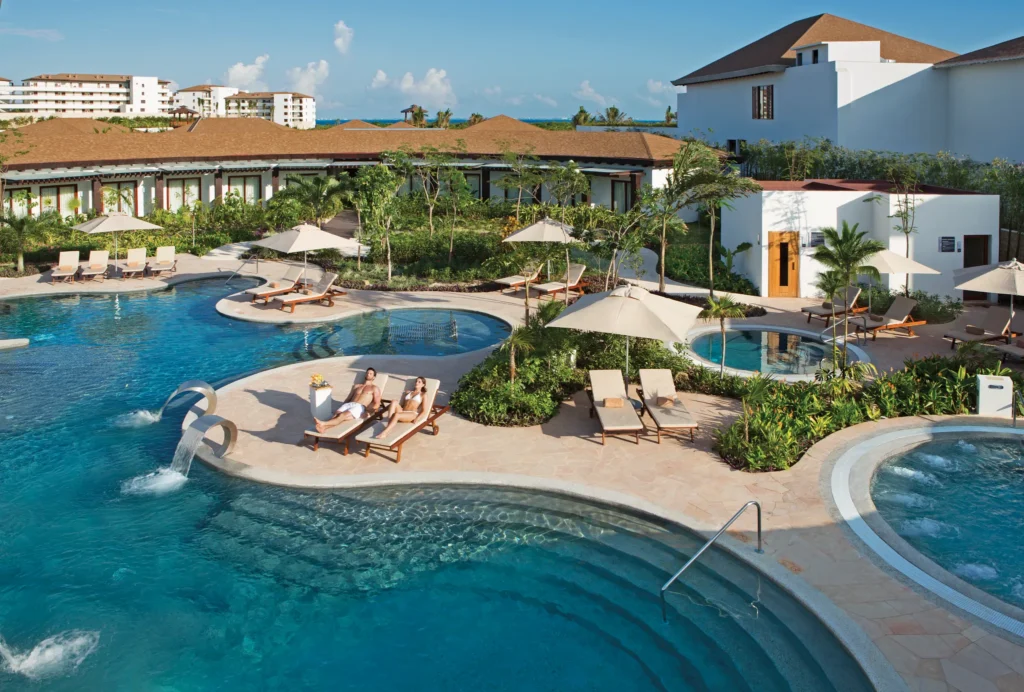 Hydrotherapy spa circuit pool with lounge chairs and tropical landscaping at Secrets Playa Mujeres Golf & Spa Resort.