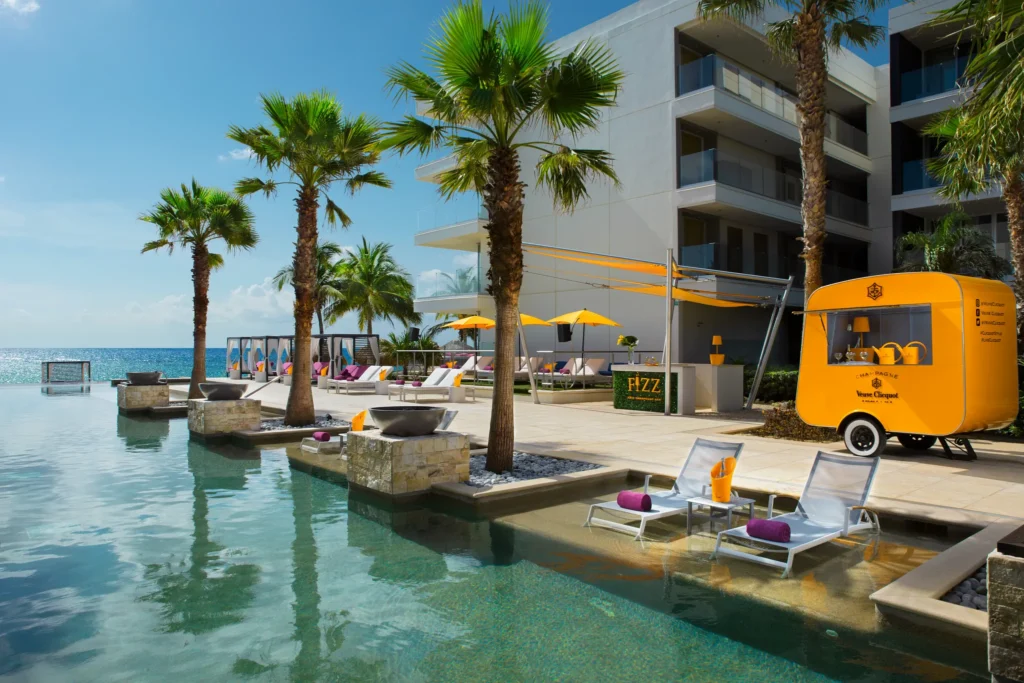 Fizz Iced Champagne Bar at Secrets Riviera Cancun featuring a luxury champagne cart, oceanfront pool views, and chic lounge seating.