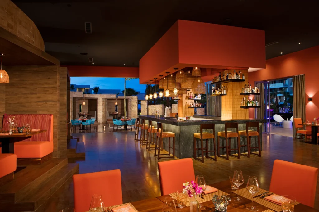 Picante Mexican restaurant at Secrets Riviera Cancun featuring contemporary décor, central bar, and warm evening ambiance.