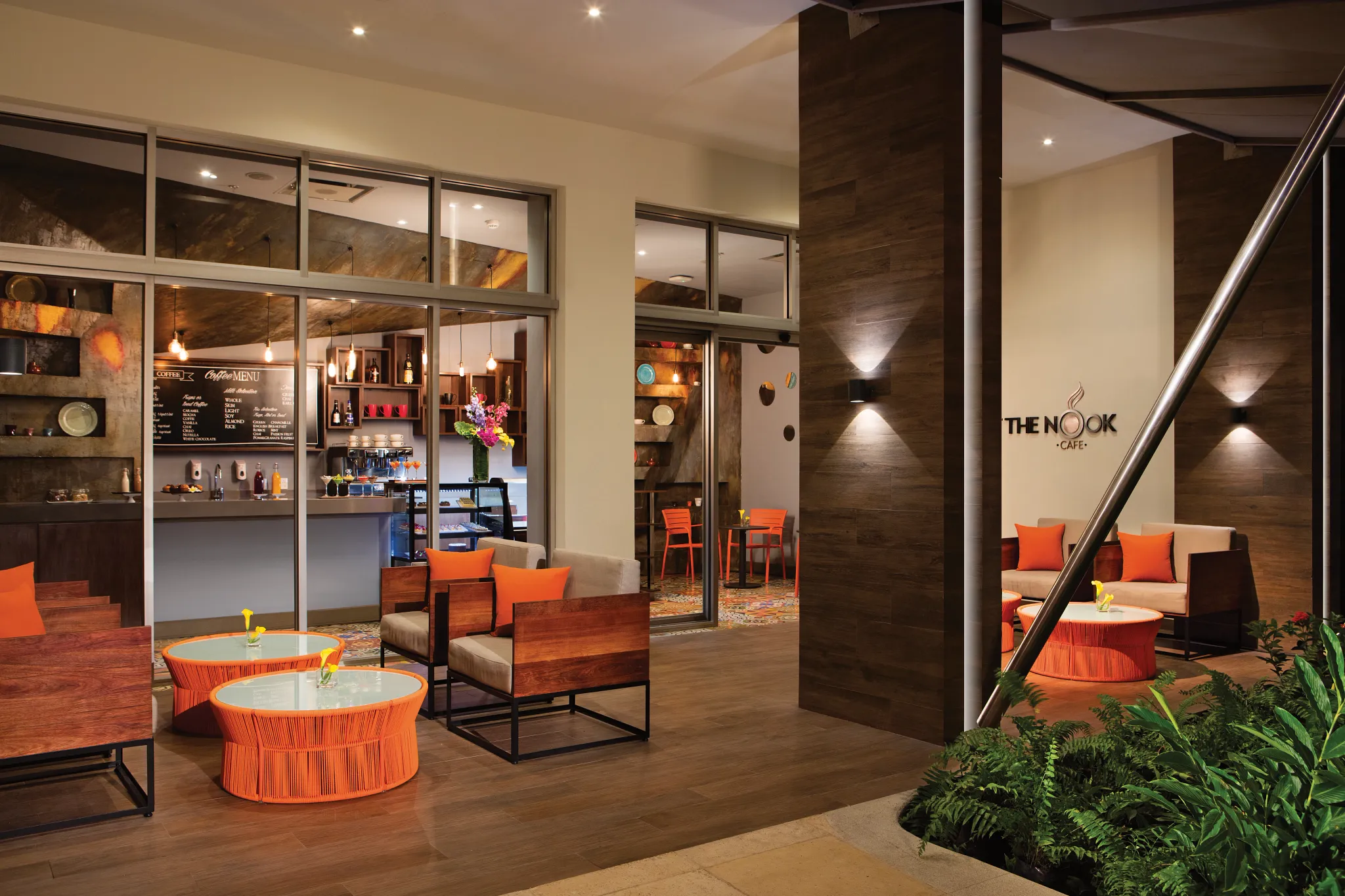 The Nook Café at Secrets Riviera Cancun featuring cozy lounge seating, premium coffee bar, and fresh pastries display.