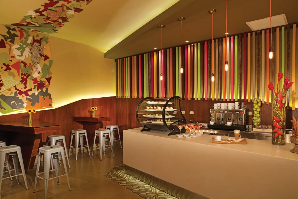 Coco Café at Secrets Royal Beach Punta Cana featuring a colorful modern coffee bar serving pastries, desserts, and premium coffee.
