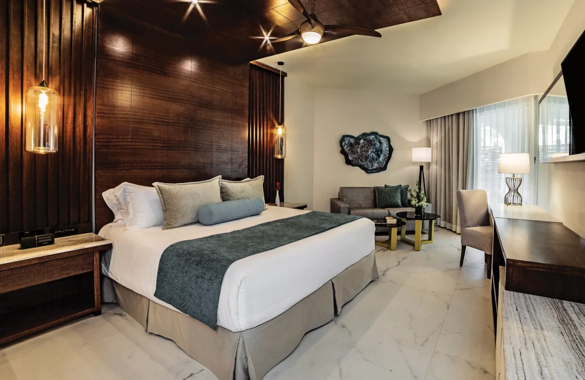 Junior Suite Pool View bedroom with king bed and sitting area at Secrets Royal Beach Punta Cana.