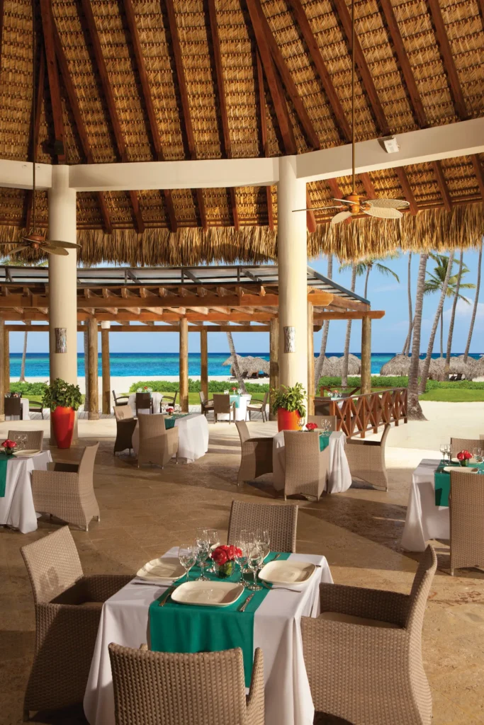 Oceana Seafood Restaurant at Secrets Royal Beach Punta Cana with open-air beachfront dining and ocean views under a thatched roof.