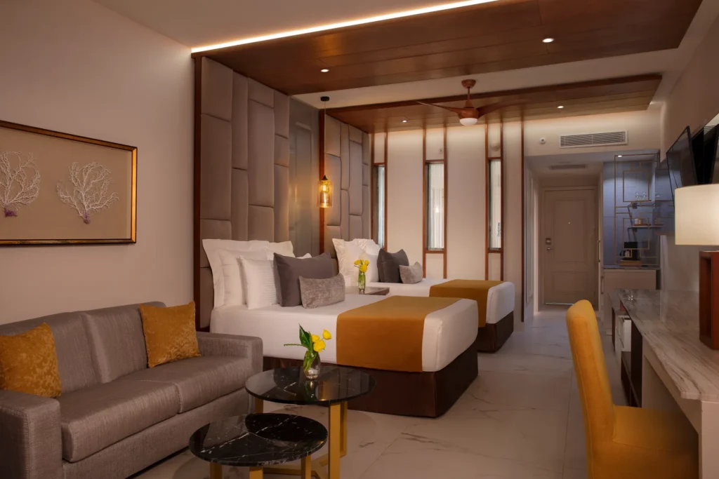 Preferred Club Junior Suite Partial Ocean View with two double beds and seating area at Secrets Royal Beach Punta Cana.