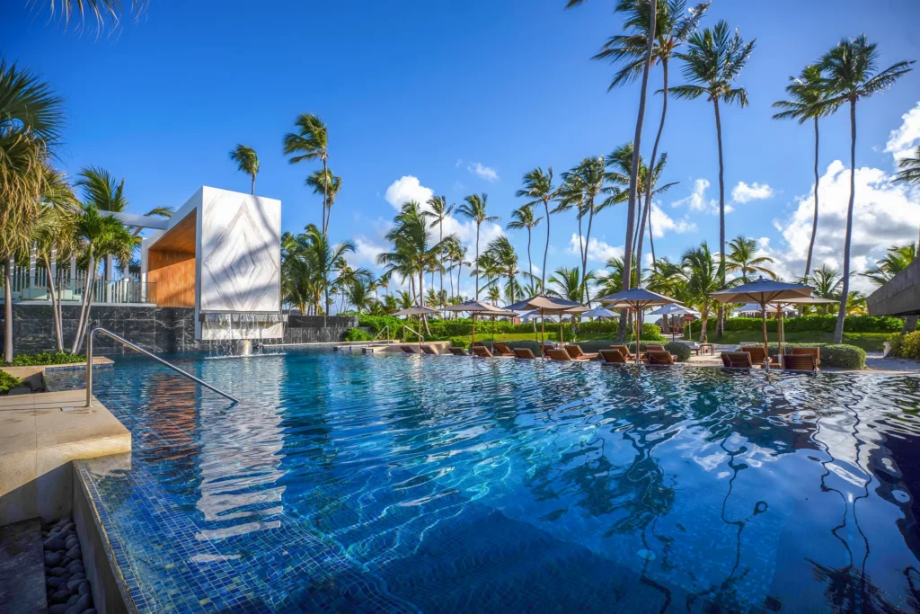 Infinity pool surrounded by palm trees at Secrets Royal Beach Punta Cana, offering a luxurious adults-only pool experience near the Caribbean beach.
