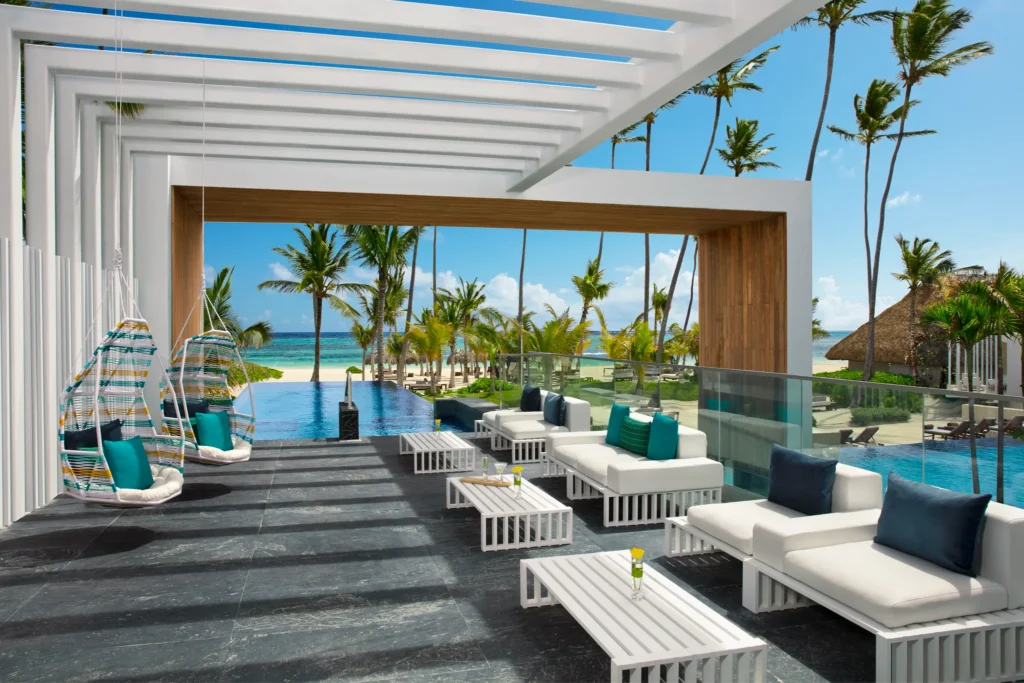 Ocean-view infinity pool solarium lounge with modern seating at Secrets Royal Beach Punta Cana.