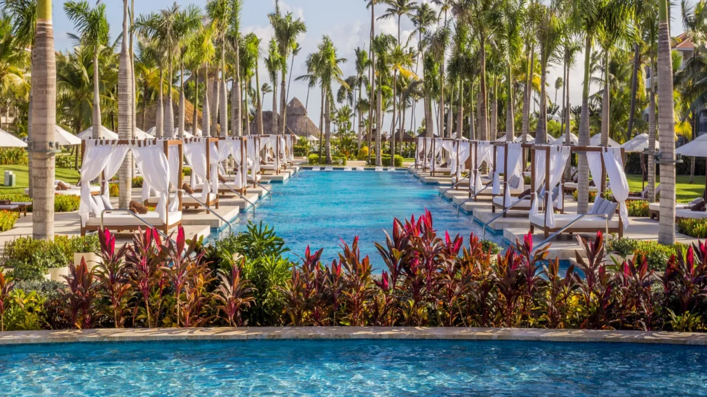 Quiet pool with private cabanas and palm trees at Secrets Royal Beach Punta Cana.