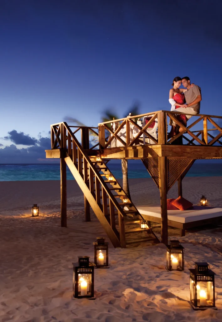 Romantic candlelit dinner on the beach at Secrets Royal Beach Punta Cana at sunset.