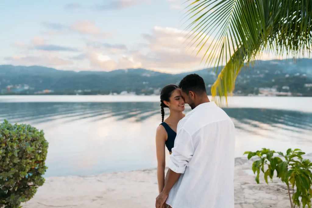 Couple embracing on a tranquil beach at sunset at Secrets St. James Montego Bay with calm Caribbean waters.