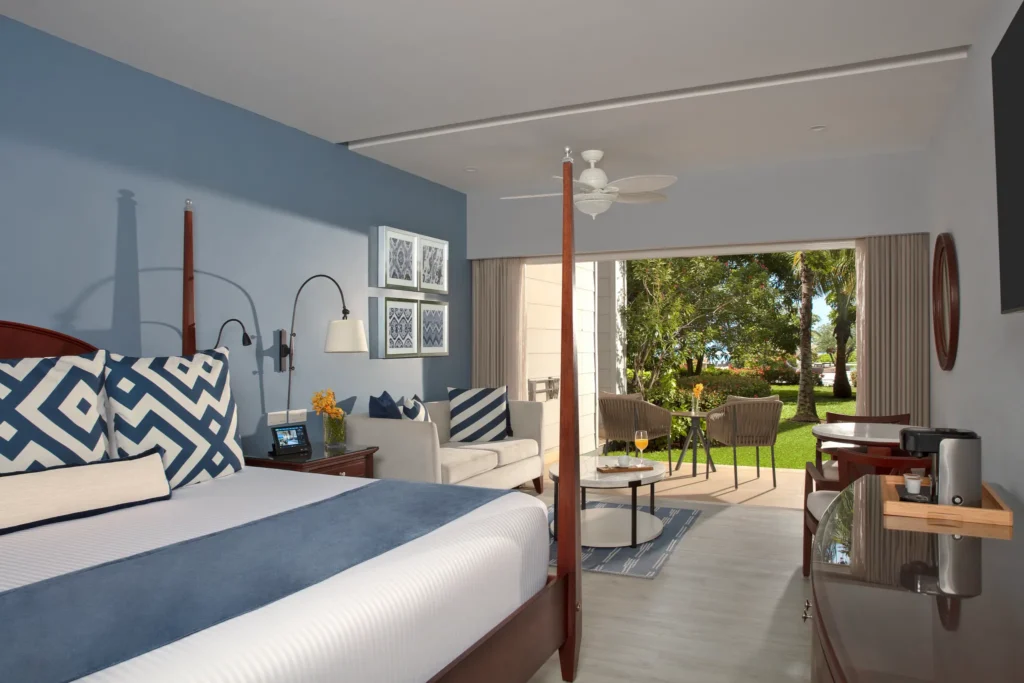 Junior Suite Garden View with king bed, sitting area, and private terrace at Secrets St. James Montego Bay overlooking tropical gardens.