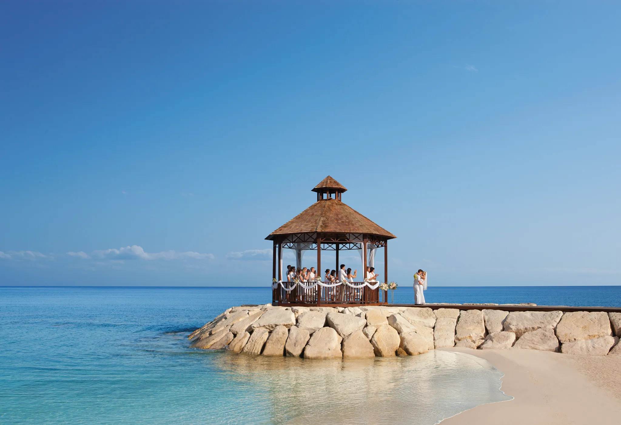 Beachside gazebo wedding setup with turquoise water and white sand at Secrets St. James Montego Bay