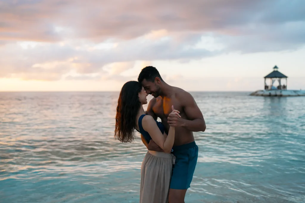 Couple dancing together at sunset in the shallow waters at Secrets St. James Montego Bay.