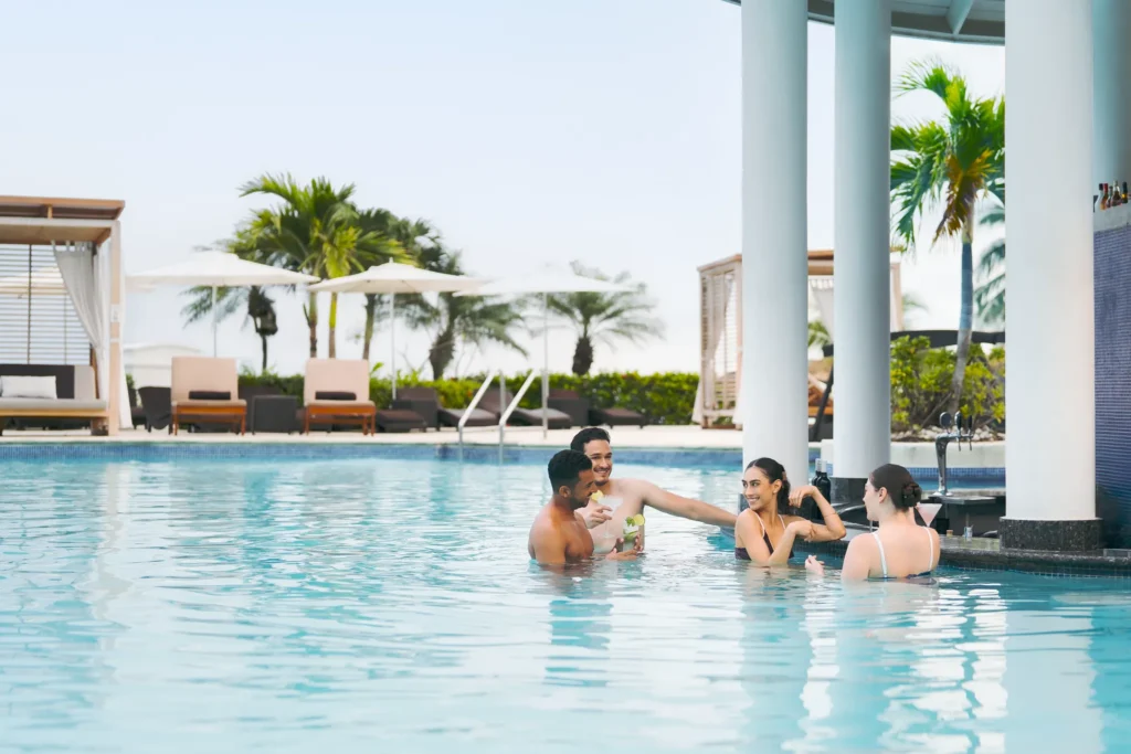 Guests enjoying drinks at a swim-up pool bar at Secrets St. James Montego Bay.