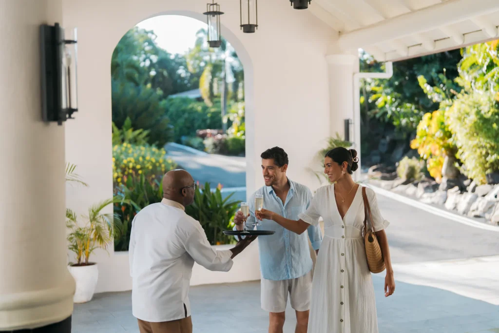 Couple welcomed with champagne at arrival entrance of Secrets St. Lucia Resort & Spa.