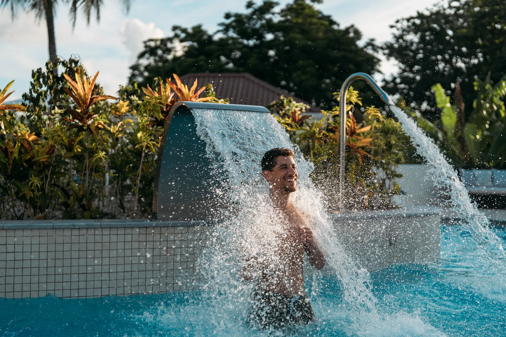 Man enjoying hydrotherapy waterfall pool at Secrets St. Lucia Resort & Spa.