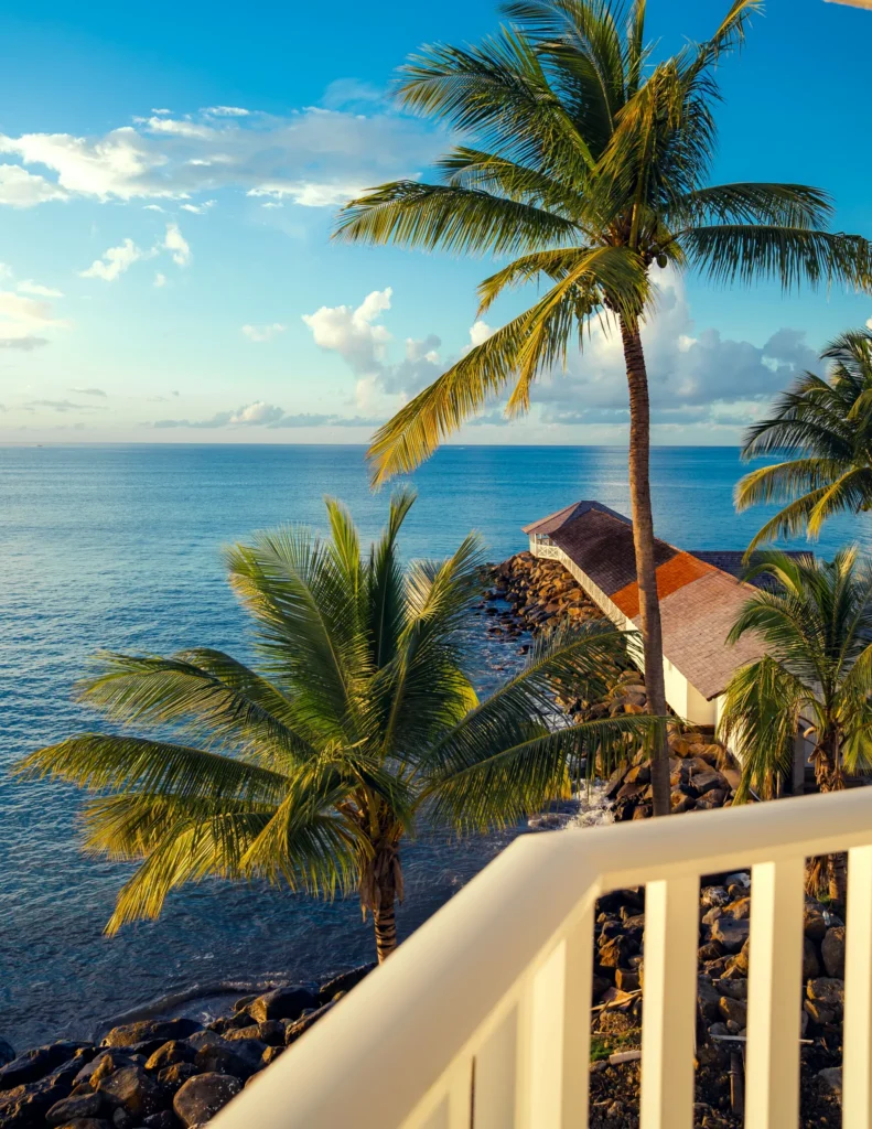 Oceanfront view with palm trees and pier from balcony at Secrets St. Lucia Resort & Spa.